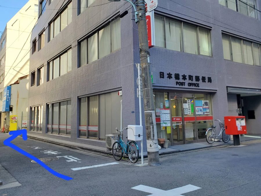 日本橋本町郵便局の角。郵便局の横の道へ入る矢印